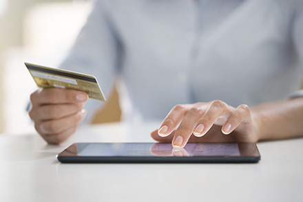 A girl is holding her debit card and making a digital payment online built by Huawei’s finance infrastructure