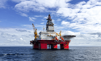 A deep-sea mining platform in the middle of the ocean on a clear day, to represent Huawei oil and gas exploration solutions